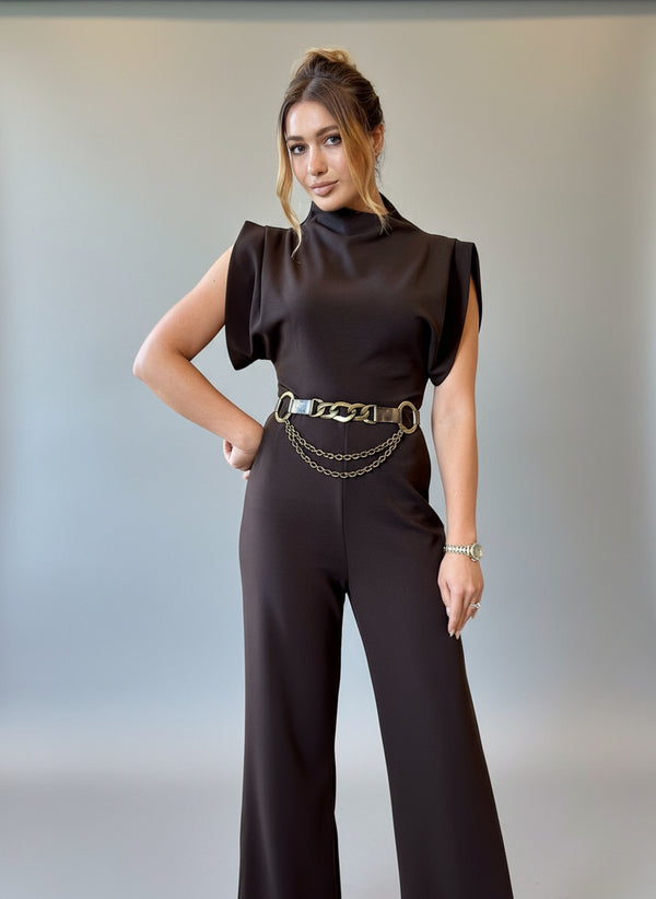 Woman wearing a black outfit with a gold belt in a living room setting
