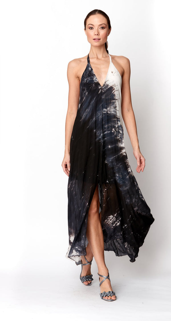 Woman wearing a black and white tie-dye halter neck dress on a white background