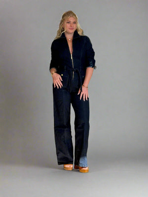 Woman wearing a navy jumpsuit in a clothing store.