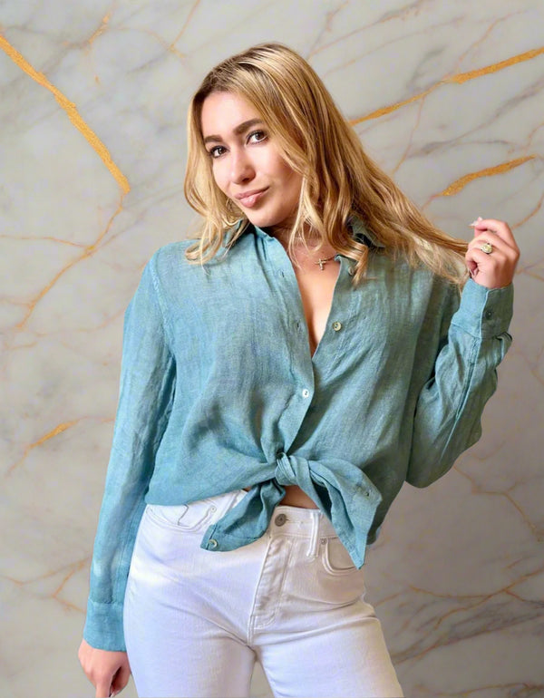 Woman wearing a light blue shirt and white pants in an indoor setting