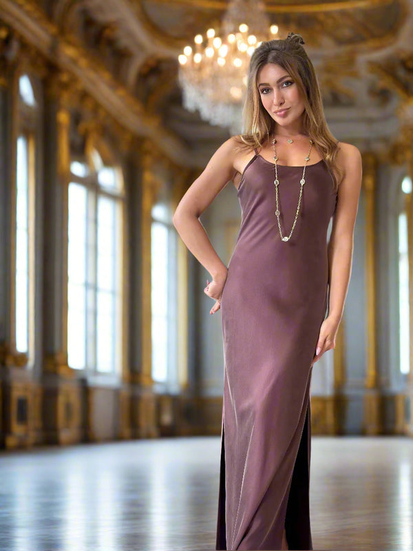 Woman in a long, dark purple dress with a chandelier in the background