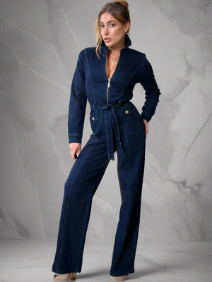 Woman wearing a navy blue jumpsuit in a living room setting