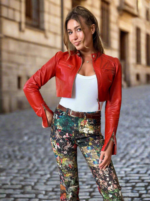 Woman wearing a red leather jacket and floral pants in an indoor setting